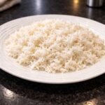 Cooked white rice served on a plate as a simple side dish.